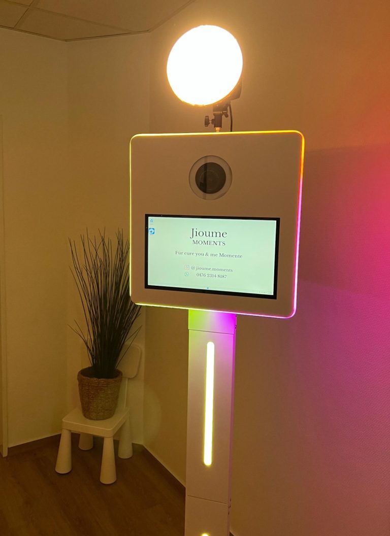 Fotobox Ein interaktives Bedienfeld mit Bildschirm und leuchtendem Oberlicht in einem Raum.